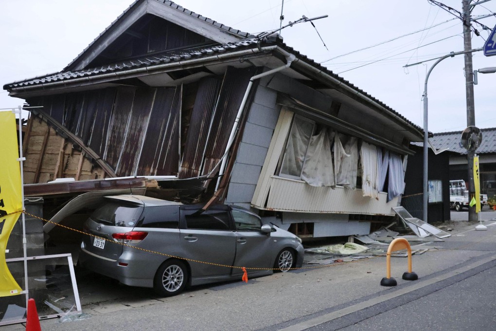 A house collapsed over a vehicle in Suzu in Ishikawa Prefecture after an earthquake rocked the region. Photo: Kyodo