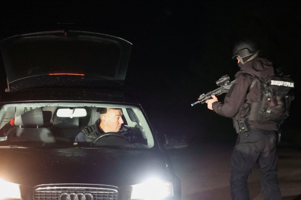 A member of Serbia’s security forces stops a driver at a checkpoint in Dubona. A suspect was arrested roughly 90km from the scene of the attacks. Photo: Reuters