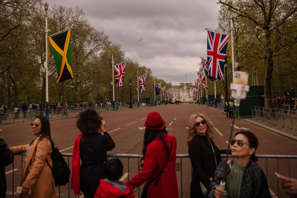People take selfies at The Mall lined with British Union and commonwealth nation flags, ahead of the coronation of King Charles III, in London. Photo: Bloomberg