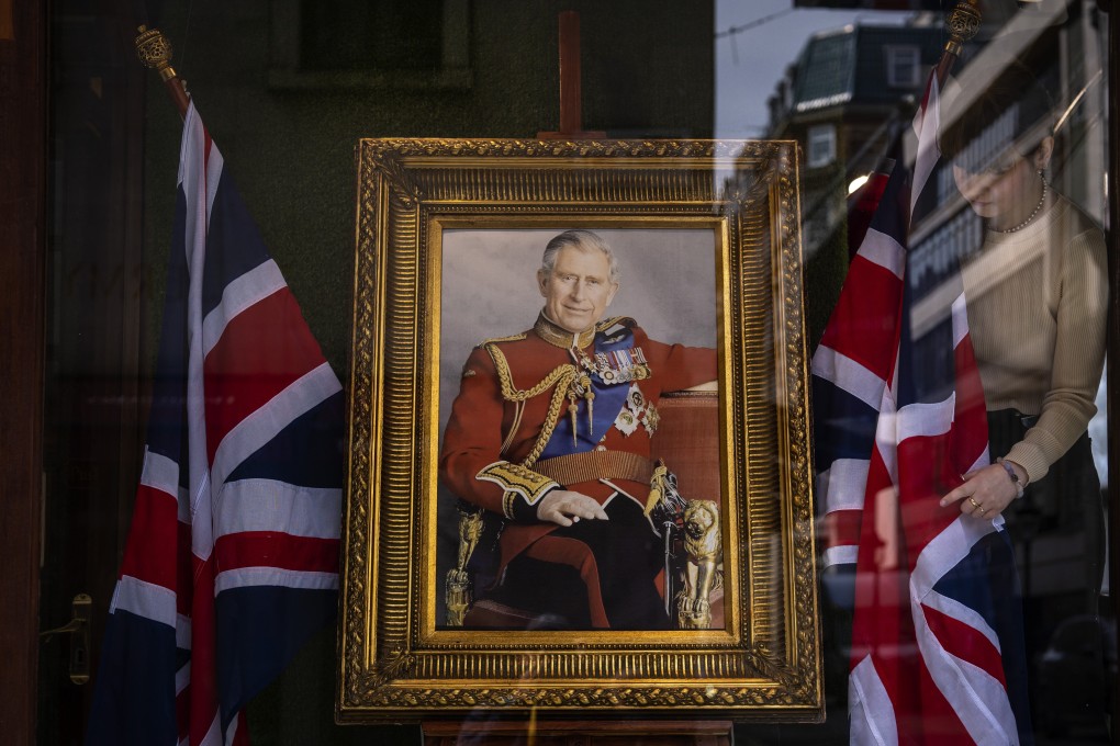 An employee arranges a shop window decorated with a painting of King Charles III in London on Thursday, ahead of Saturday’s coronation ceremony. Photo: AP