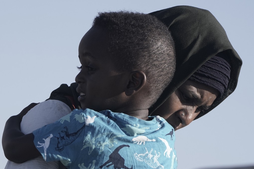 A Sudanese evacuee carries her son as they leave the USNS Brunswick at Jeddah port, Saudi Arabia. Photo: AP