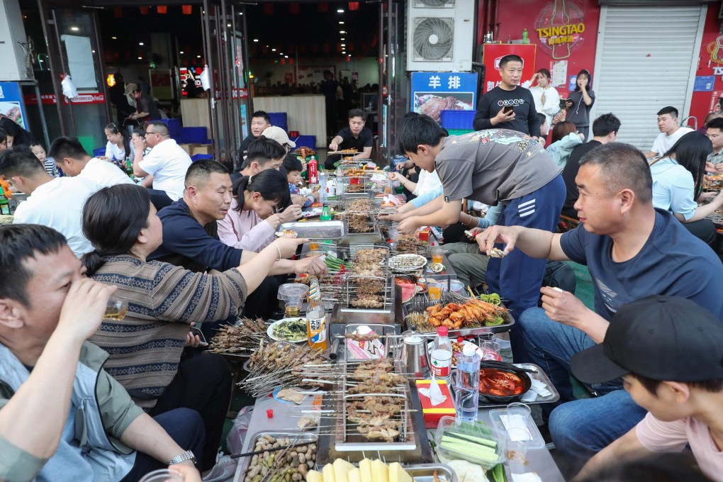 People eating barbecued food during the 5-day Labour Day holiday in Zibo, in China’s eastern Shandong province. Photo: AFP