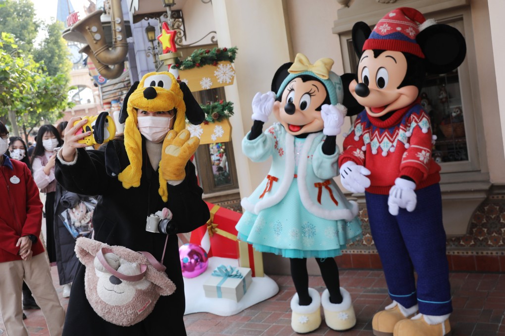 A tourist takes a selfie with Mickey Mouse and Minnie Mouse at Shanghai Disneyland. Photo: VCG