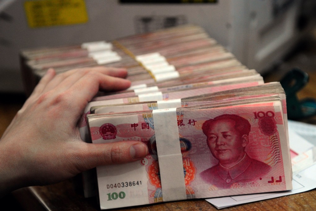 A Chinese bank worker prepares to count the stacks of 100 Chinese yuan notes at a bank in Hefei, east China’s Anhui province. Photo: AFP