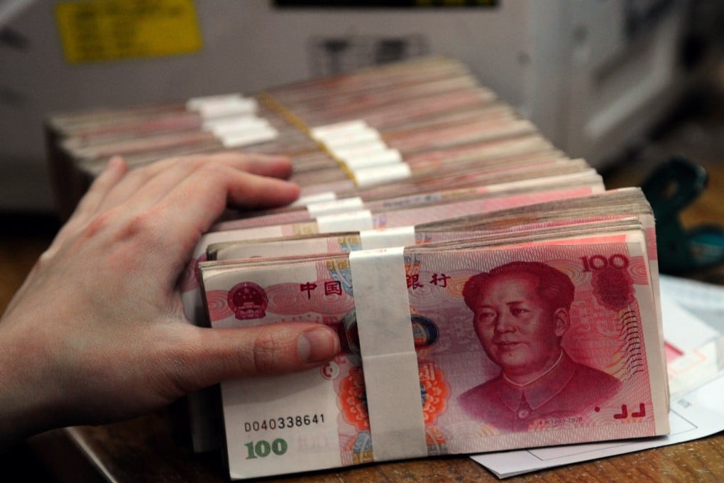 A Chinese bank worker prepares to count the stacks of 100 Chinese yuan notes at a bank in Hefei, east China’s Anhui province. Photo: AFP