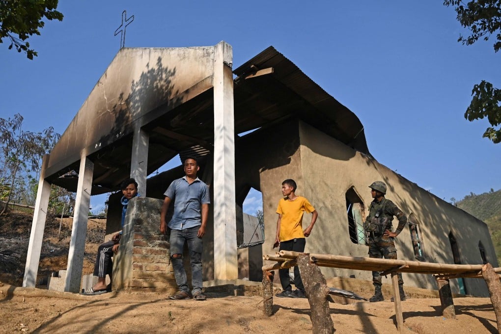 An Indian soldier stands alongside villagers in front of a ransacked church that was set on fire by a mob earlier this month in the Senapati district of India’s Manipur state. Photo: AFP