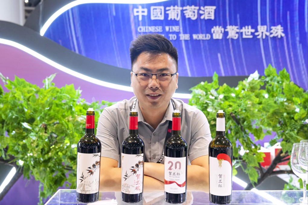 Lu Yongliang, a senior official at Helan Hong Winery,  Ningxia, shows off its products at a major trade show in Hong Kong. Photo: Elson Li
