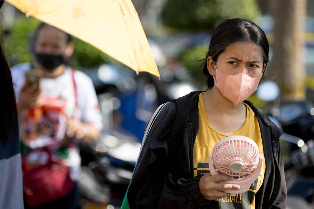 A woman cools herself during hot weather in Bangkok. Photo: AFP