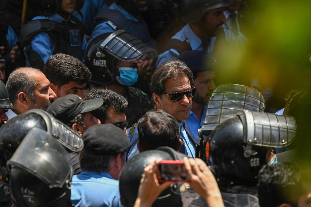 Policemen escort Pakistan’s former pime minister Imran Khan (middle, with sunglasses) as he arrives at the high court in Islamabad on May 12, 2023. Photo: AFP