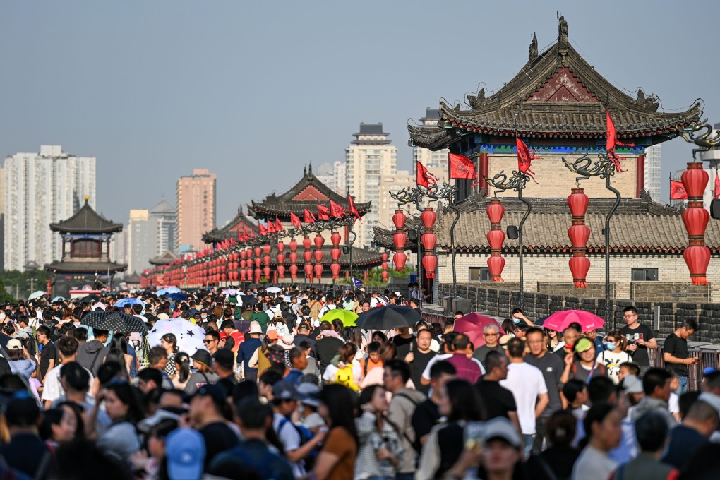 People visit the ancient city wall in Xian in northwest China’s Shaanxi province on April 30.  China’s growing middle class offers a massive market and a strong incentive for foreign companies to remain in the country. Photo: AFP.