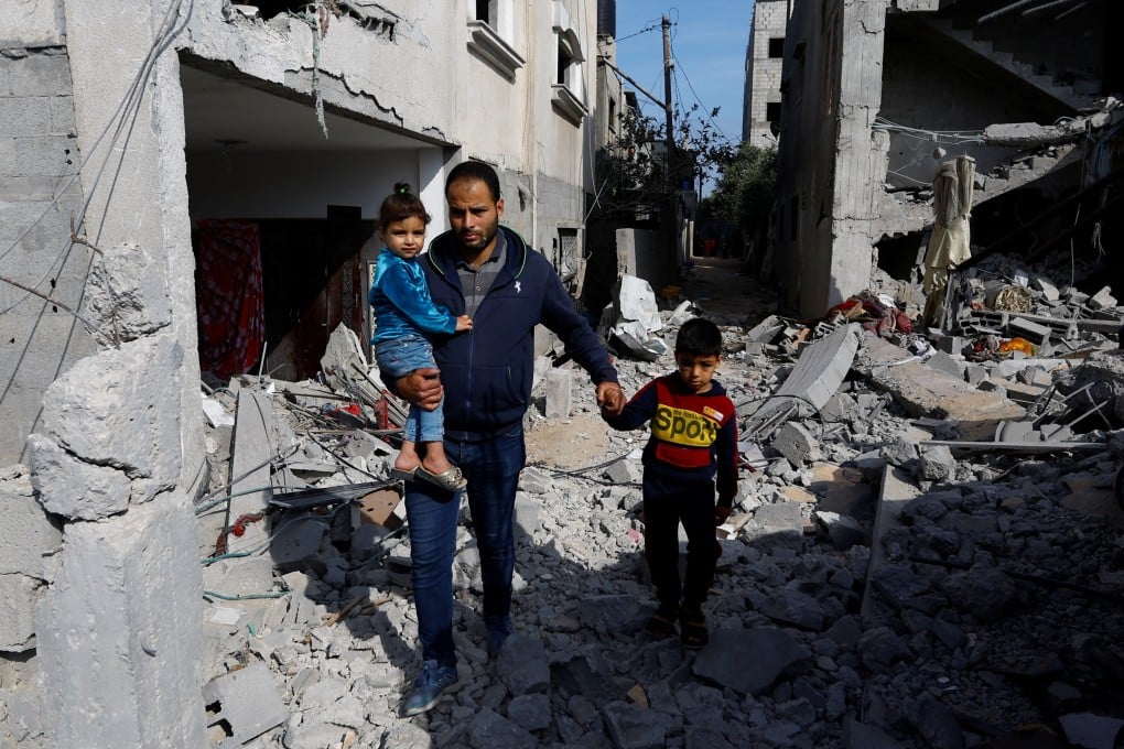 Palestinians walk among the rubble of buildings, which were damaged in an Israeli strike during Israel-Gaza fighting, after a ceasefire was agreed between Palestinian factions and Israel, in Deir Al-Balah, central Gaza Strip, on Sunday. Photo: Reuters