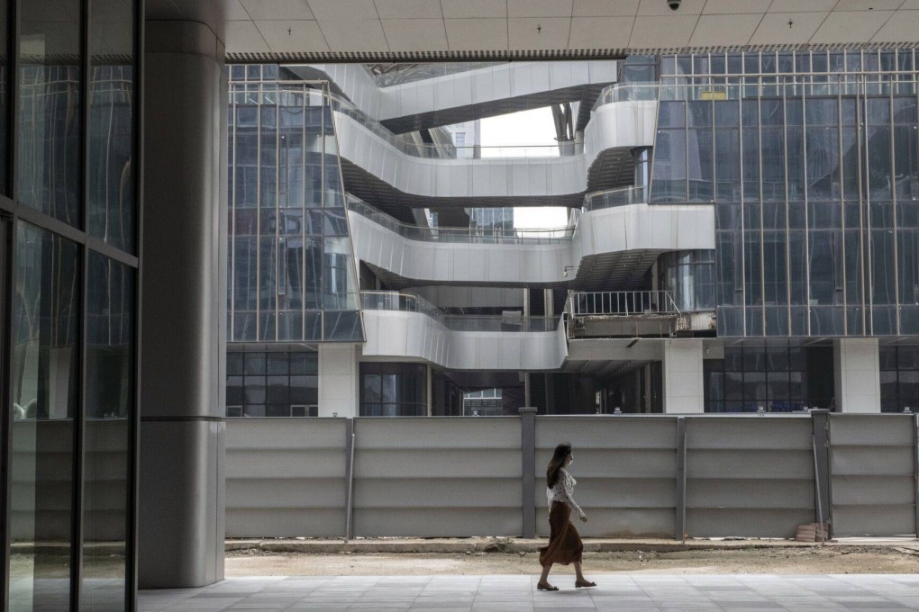 A pedestrian passes a construction site for a commercial building in the Pazhou area of Guangzhou on May 9. Mainland China has emerged as a favourite destination for commercial property investment since Beijing ended its zero-Covid policy, taking in a fifth of outbound capital from Singapore, one of the Asia-Pacific’s leading investment sources. Photo: Bloomberg