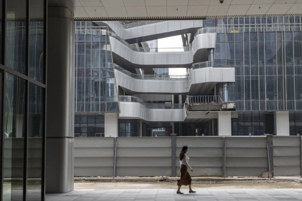 A pedestrian passes a construction site for a commercial building in the Pazhou area of Guangzhou on May 9. Mainland China has emerged as a favourite destination for commercial property investment since Beijing ended its zero-Covid policy, taking in a fifth of outbound capital from Singapore, one of the Asia-Pacific’s leading investment sources. Photo: Bloomberg