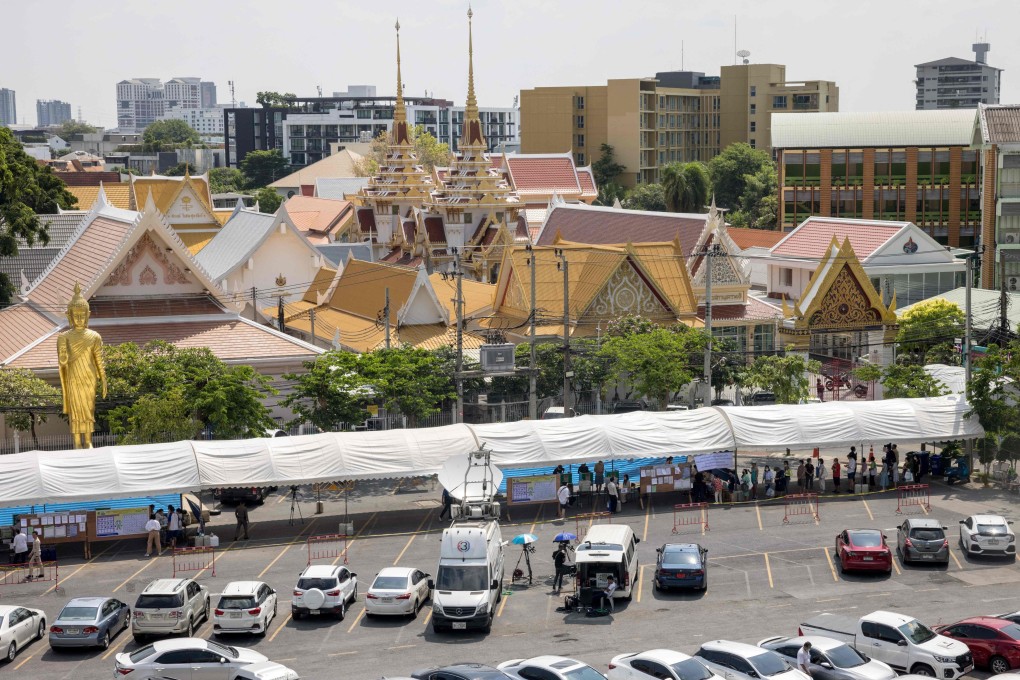 Voters queue to cast their ballots at a polling station outside a Buddhist temple in Bangkok during Thailand’s general election. Photo: AFP
