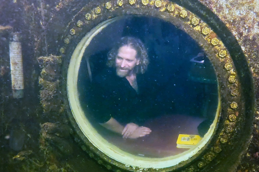 Dr Joseph Dituri peers out of a large porthole inside the Jules’ Undersea Lodge in Florida. Photo: Frazier Nivens/Florida Keys News Bureau via Reuters