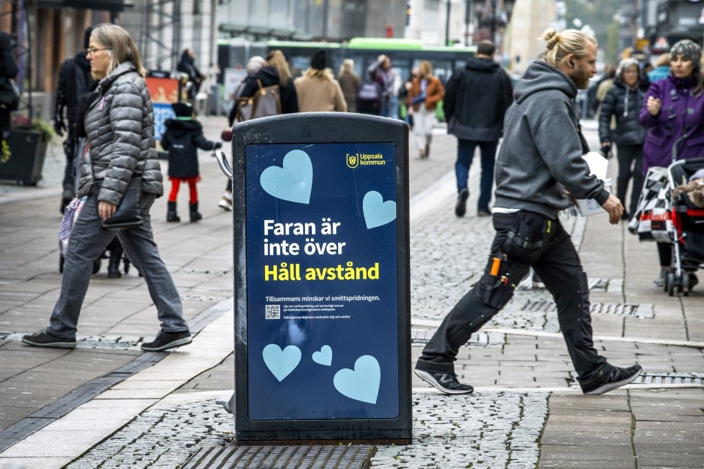 A rubbish bin with words that mean “The danger is not over - Keep your distance” on a pedestrian street in central Uppsala in Sweden on Wednesday, Oct. 21, 2020. Photo: TT News Agency via AP.