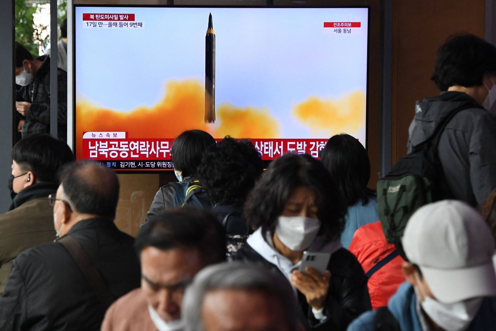 People in Seoul watch a television screen showing a news broadcast with file footage of a North Korean missile test on April 13, 2023. Photo: AFP