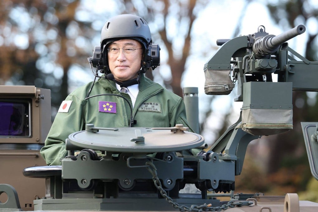 Japanese Prime Minister Fumio Kishida rides atop a tank during a military review at the Japanese Ground Self-Defence Force’s Camp Asaka in Tokyo on November 27, 2021. Kishida has ordered a sharp rise in defence spending to 2 per cent of gross domestic product by 2027. Photo: AFP