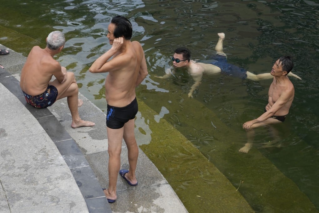 On Tuesday, May 16, residents cool off along a canal during a heat wave in Beijing. Photo: AP Photo