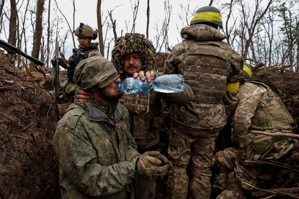 A Ukrainian soldier gives water to a captured Russian army serviceman near the city of Bakhmut. Photo: Radio Free Europe via Reuters