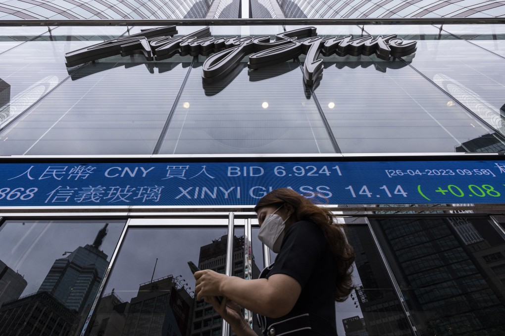 A pedestrian passes by the Hong Kong Stock Exchange electronic screen in Hong Kong on April 26, 2023. Photo: AP