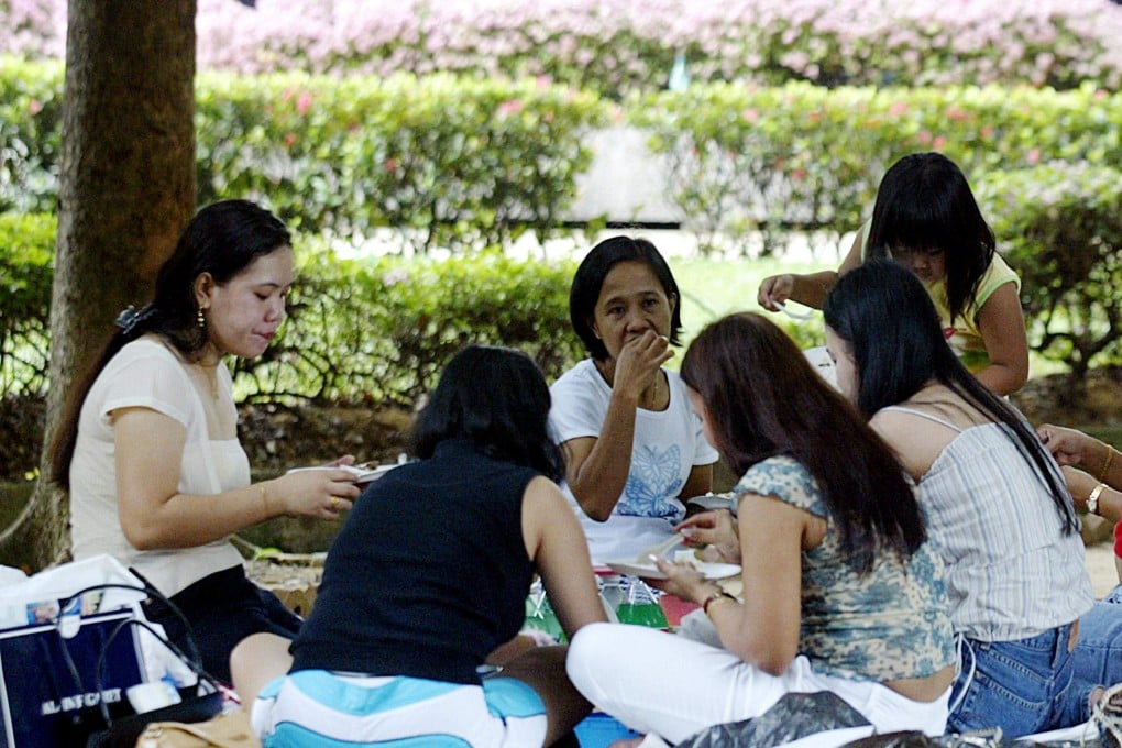Foreign domestic workers enjoy a picnic in Singapore. Many Asian women are driven by poverty to seek work abroad as domestic helpers. A lot of them end up in Singapore or Hong Kong. South Korea could soon be another hotspot. File photo: AFP