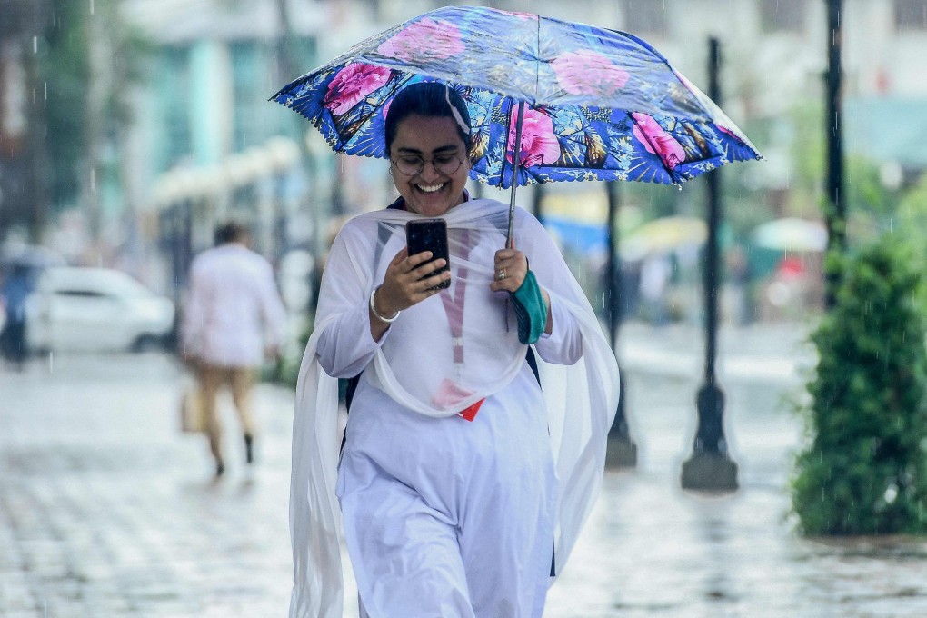 An Indian commuter checks her mobile phone as she walks along a path in Srinagar.  Many Asian women are running small businesses, often alongside other work, with digital payments helping them to increase their incomes. File photo: AFP