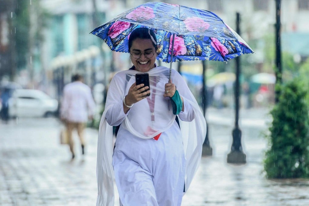 An Indian commuter checks her mobile phone as she walks along a path in Srinagar. Many Asian women are running small businesses, often alongside other work, with digital payments helping them to increase their incomes. File photo: AFP