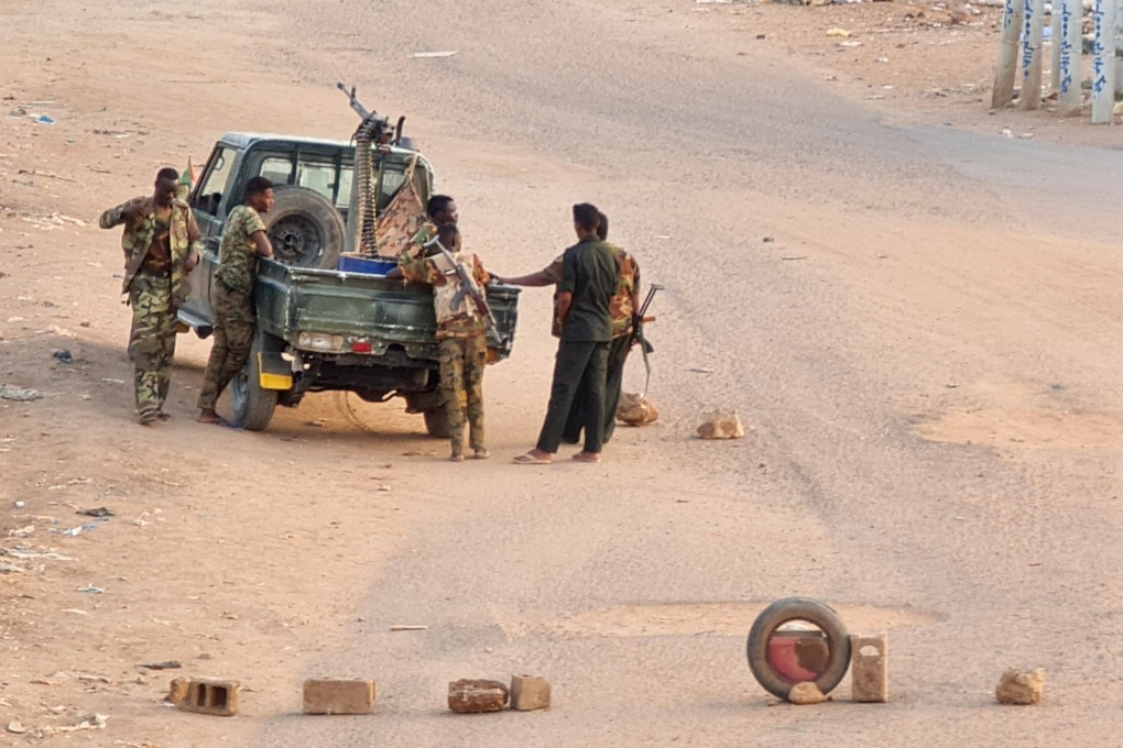 Soldiers of the Sudanese army stand near their vehicle on a road blocked with bricks in Khartoum, Sudan on Saturday. Photo: AFP
