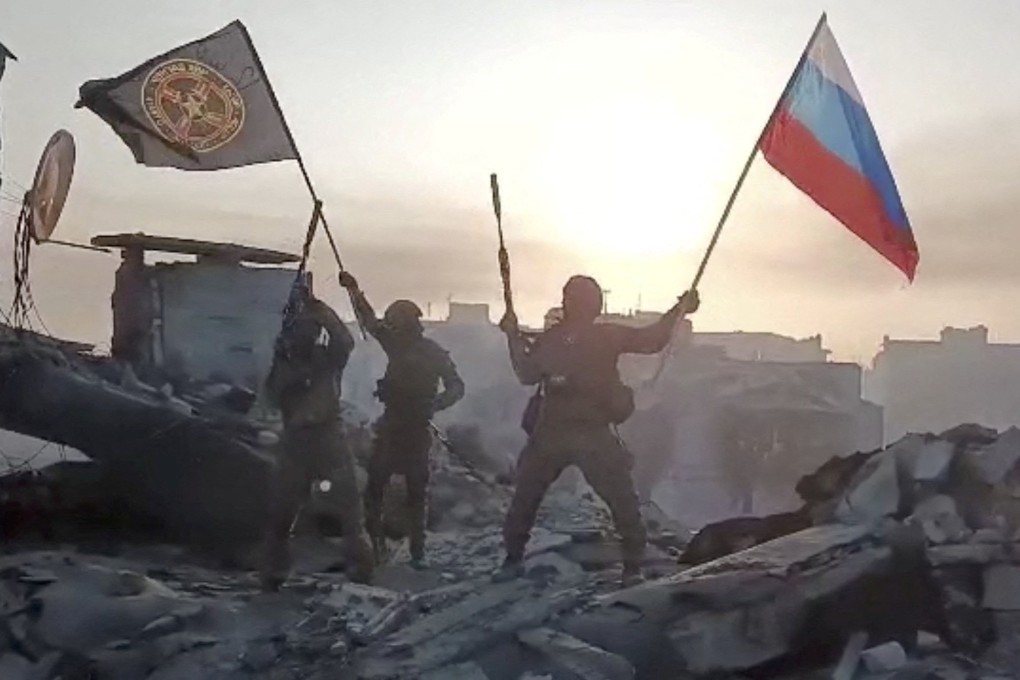 Members of Wagner group wave a Russian flag and Wagner Group’s flag on the rooftop of a damaged building in Bakhmut, Ukraine. Photo: Telegram channel of Concord group via AFP