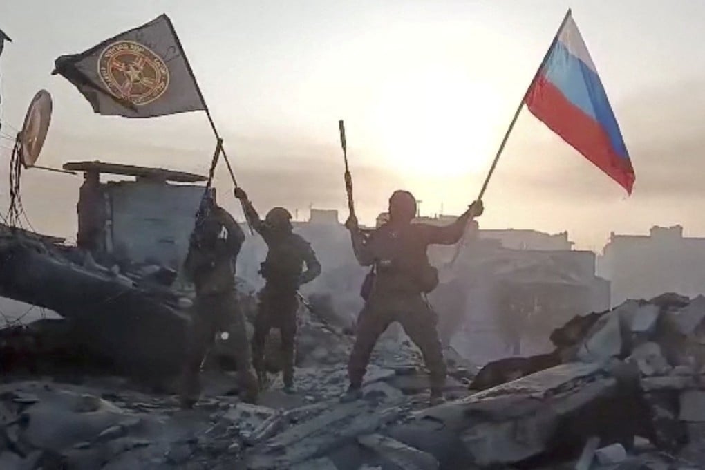 Members of Wagner group wave a Russian flag and Wagner Group’s flag on the rooftop of a damaged building in Bakhmut, Ukraine. Photo: Telegram channel of Concord group via AFP