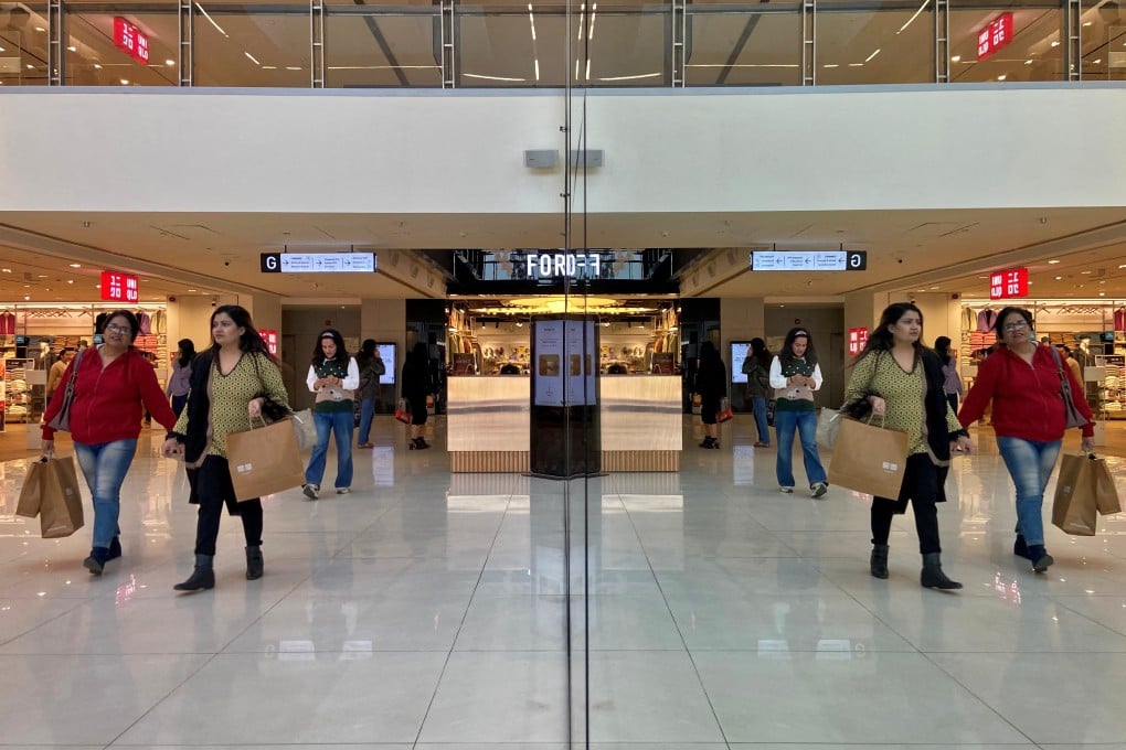 Shoppers are reflected in mirror inside a shopping centre in New Delhi on December 14, 2022. India’s commercial property sector, and its real estate market as a whole, is defying property trends seen elsewhere around the globe. Photo: Reuters