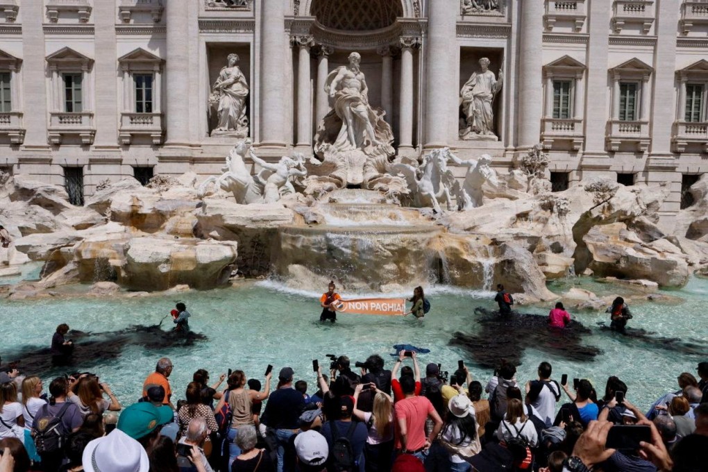 In an image obtained from social media, climate activists pour vegetable charcoal in the Trevi Fountain water, during a protest against fossil fuels in Rome, Italy on Sunday. Photo: Alessandro Penso / MAPS via Reuters