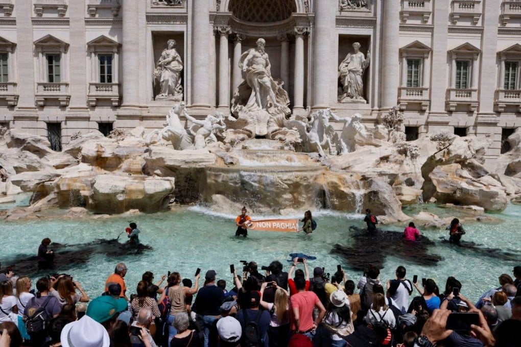 In an image obtained from social media, climate activists pour vegetable charcoal in the Trevi Fountain water, during a protest against fossil fuels in Rome, Italy on Sunday. Photo: Alessandro Penso / MAPS via Reuters