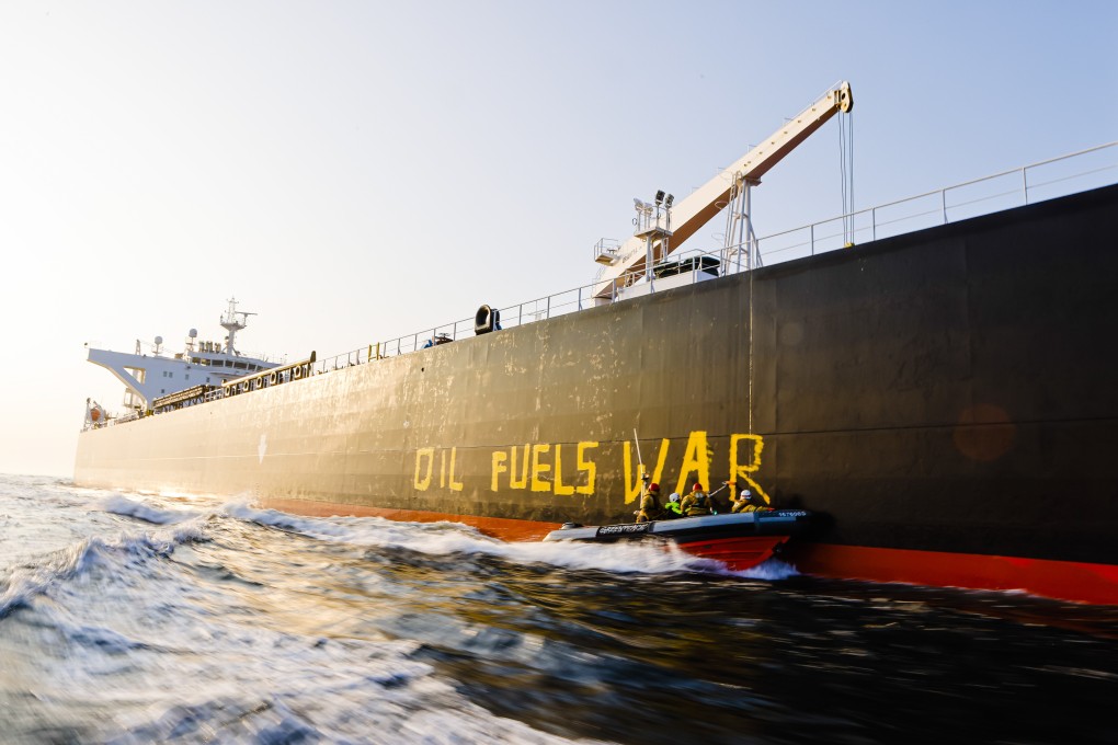 Activists from the environmental organisation Greenpeace paint the words “Oil fuels war” on the hull of a ship carrying Russian oil on the Baltic Sea. Photo: dpa