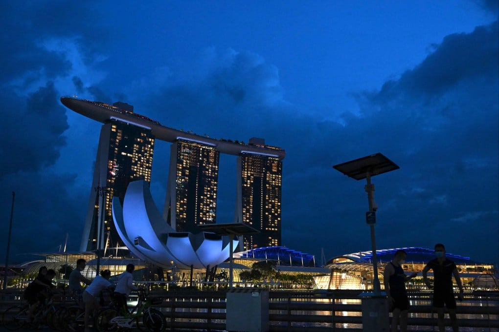 People are seen along a pavement overlooking the Marina Bay Sands in Singapore on November 19, 2020. Photo: AFP