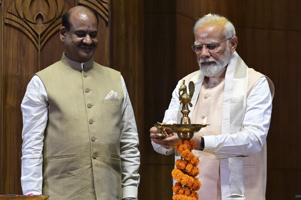 Indian prime minister Narendra Modi lights a lamp after installing a royal golden sceptre near the chair of the speaker, as speaker of the lower house Om Birla watches, during the start of the inaugural ceremony of the new parliament building, in New Delhi, India. Photo: AP