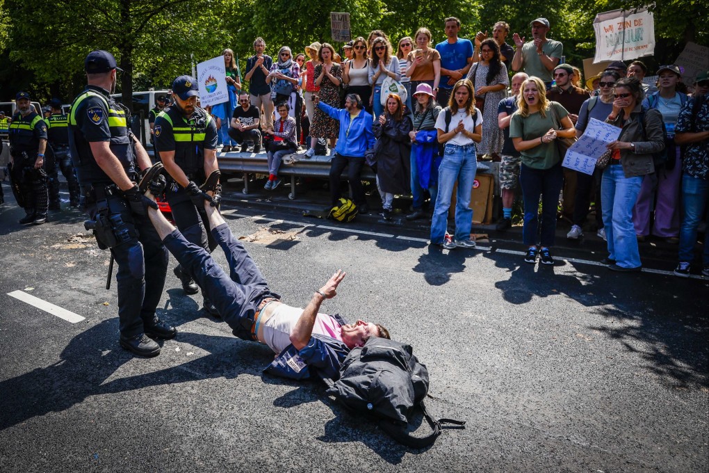 Police remove an activist from the Extinction Rebellion protest group on the A12 in The Hague, The Netherlands on Saturday. Photo: EPA-EFE