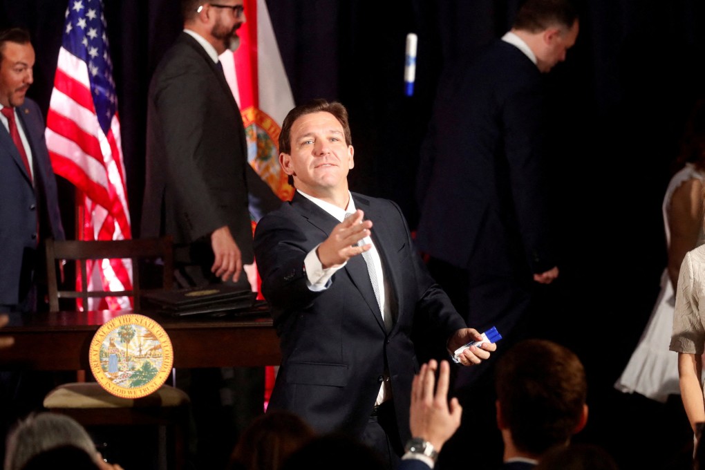 Florida Governor Ron DeSantis tosses a pen to students while signing five state bills into law after giving a press conference at Cambridge Christian School in Tampa, Florida, on May 17. Photo: Reuters