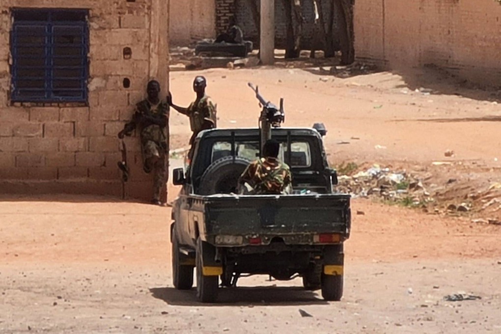 Sudanese army soldiers rest next to a building in Khartoum during a ceasefire that has allowed beleaguered civilians to venture out, even as they await safe aid corridors and escape routes. Photo: AFP