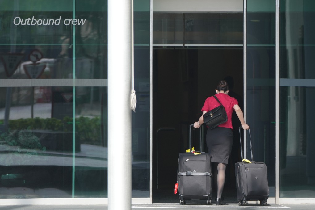 A Cathay Pacific Airways staff member wheels luggage towards an entrance to the company’s headquarters at Chek Lap Kok on May 25. Photo: Sam Tsang