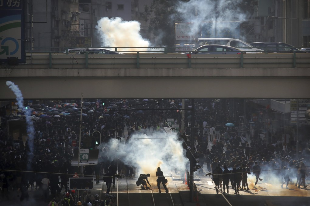 Demonstrators react as police officers fire tear gas during a protest in Hong Kong in November 2019. Photo: AP