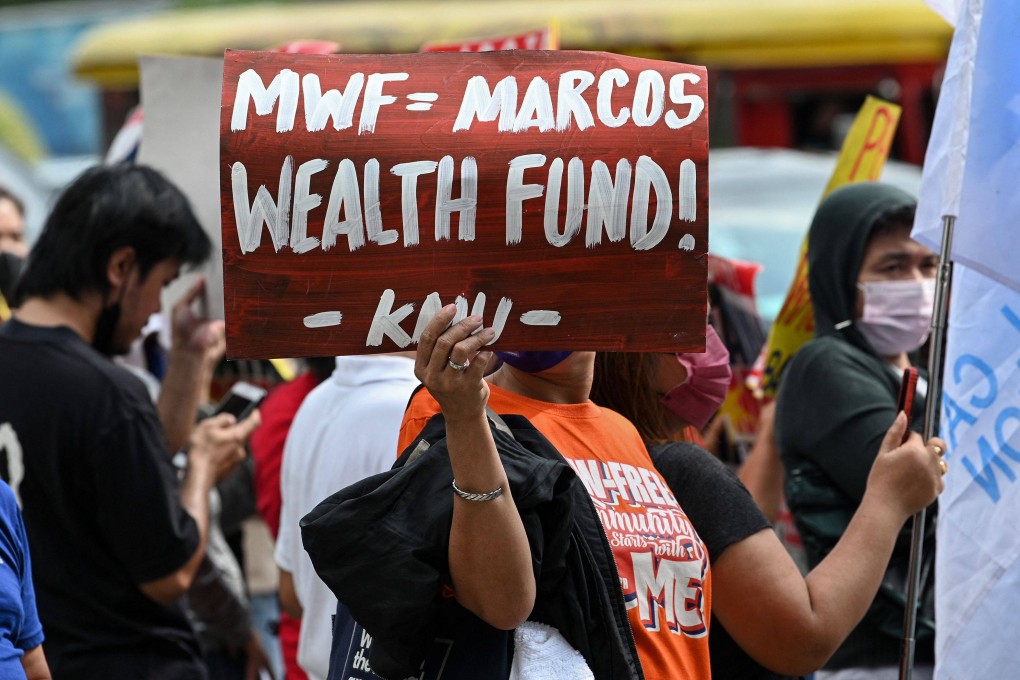 A protester holds a placard during a rally in front of the House of Representatives in Quezon City on December 12, 2022, as legislators deliberate on the sovereign wealth fund proposed law. Photo: AFP