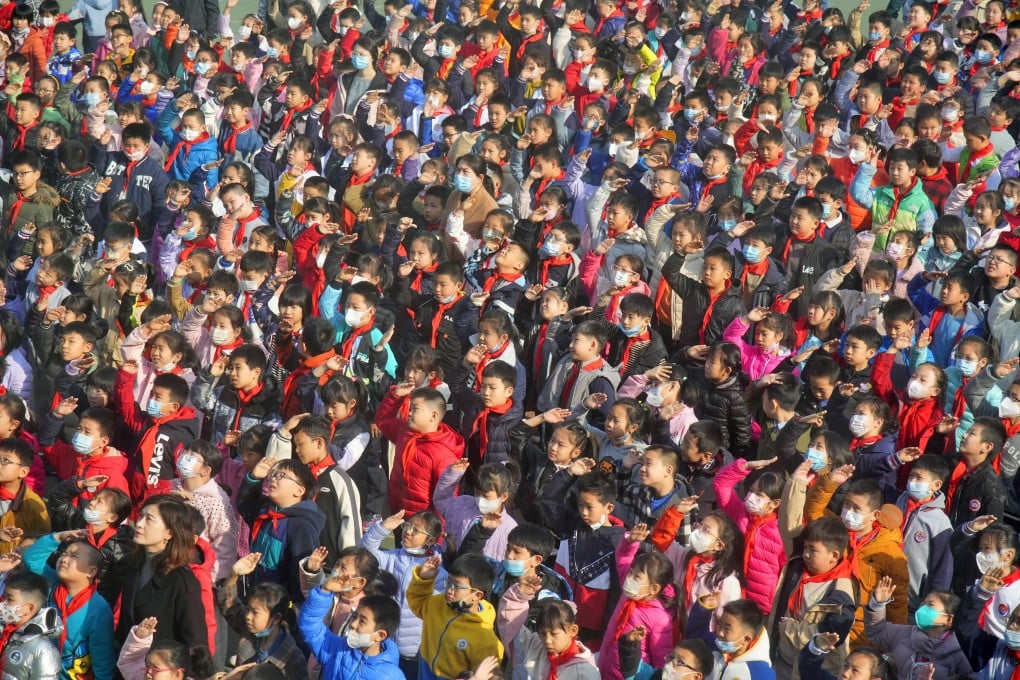 Primary school students salute the national flag in Yantai, in China’s Shandong Province. China has recently reported a drop in its population for the first time since the 1960s. Photo: Getty Images
