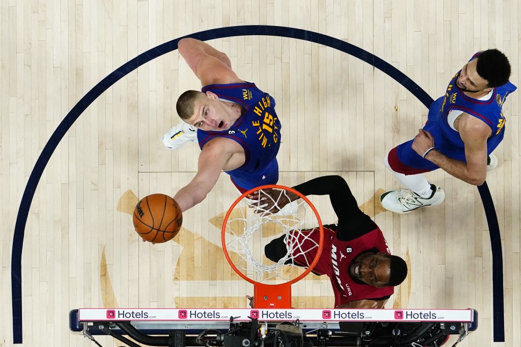 Denver Nuggets centre Nikola Jokic reaches for a rebound next to Miami Heat’s Bam Adebayo during the second half of Game 1. Photo: AP