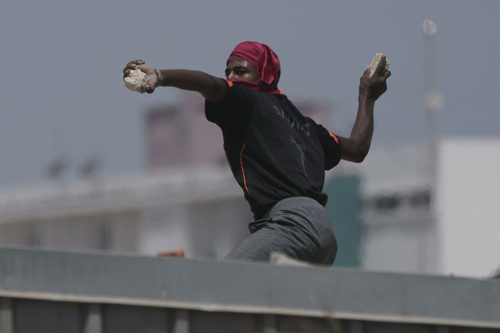 A demonstrator throws a rock at riot police during a protest at the Cheikh Anta Diop University campus in Dakar, Senegal. Photo: AP