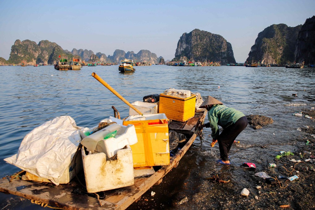A woman collects floating waste from Vietnam’s Ha Long Bay. The beauty spot is getting a reputation for marine pollution, despite such clean-ups. Photo: AFP