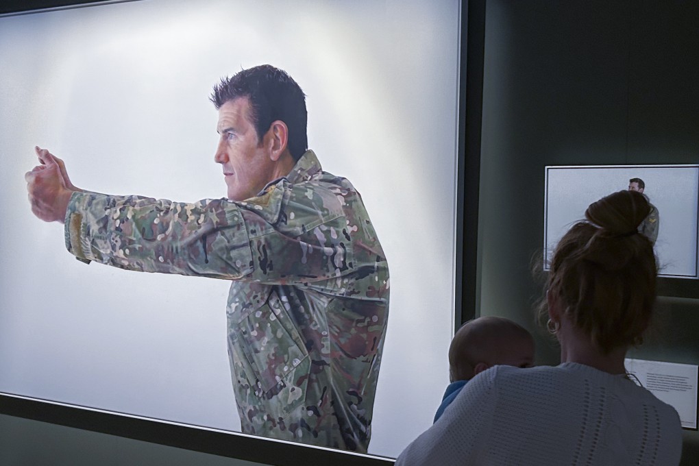 A visitor looks at a display featuring decorated war veteran Ben Roberts-Smith at the Australian War Memorial on Friday. In addition to the killing, he’d engaged in a “campaign of bullying” against another soldier, the judge said, including threatening “a bullet in the back of the head”. Photo: AP