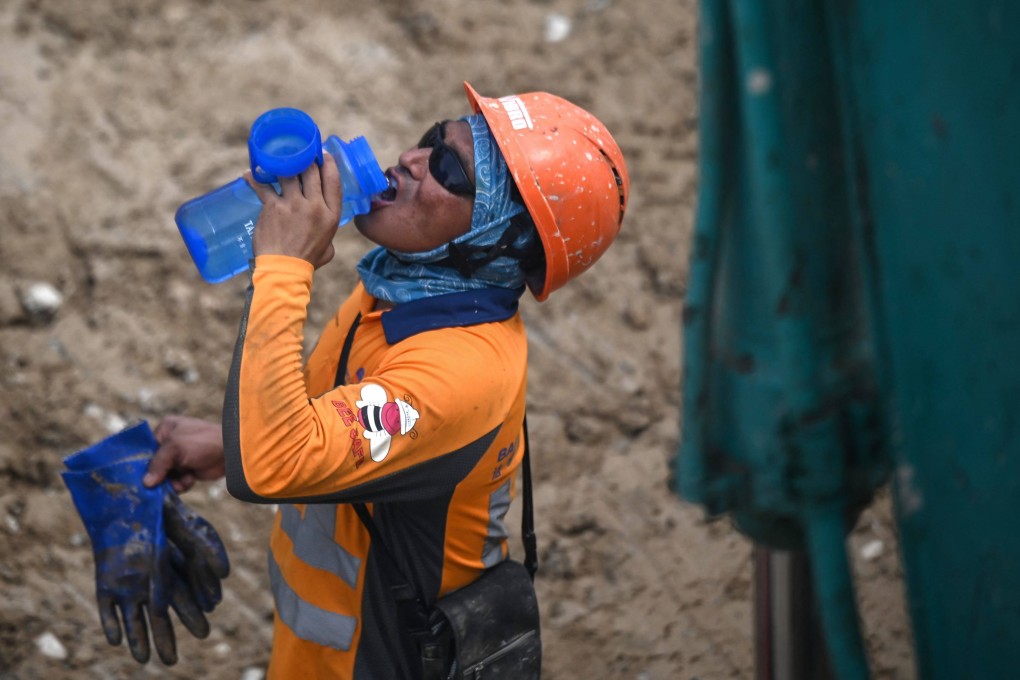 A construction worker takes a drink during hot weather in Hong Kong on June 2. Raising public awareness of the health risks of heat is important. Photo: AFP