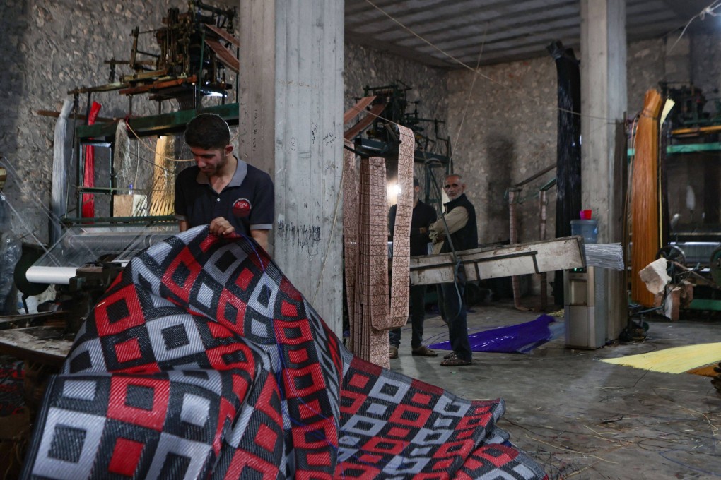 Men work at a factory making mats and rugs from recycled plastic, in Sarmada in Syria’s northwestern Idlib province. Photo: AFP
